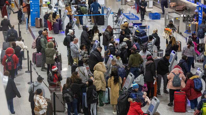 Early morning travelers check in before their flights at Hartsfield-Jackson International Airport Saturday, Dec. 24, 2022. (Photo: Steve Schaefer / steve.schaefer@ajc.com)