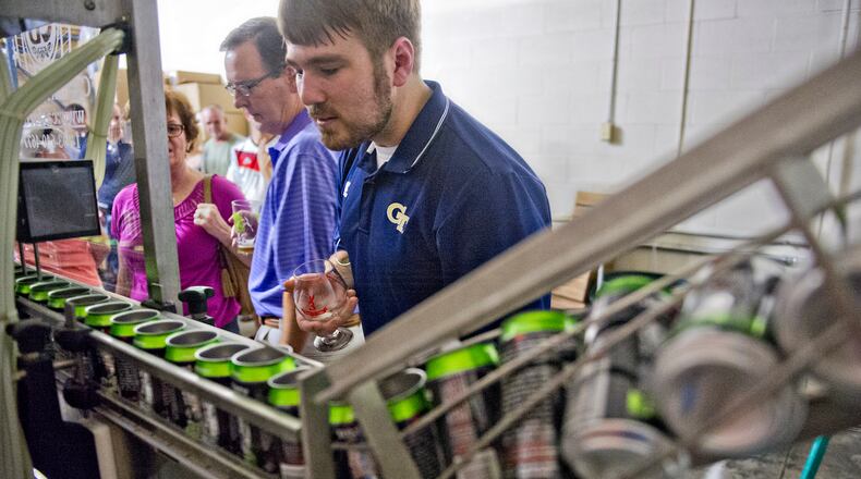Matt Huggins (right) and Mat Schenck check out the bottling equipment at Red Hare Brewery in Marietta during the company's third anniversary party in 2014.