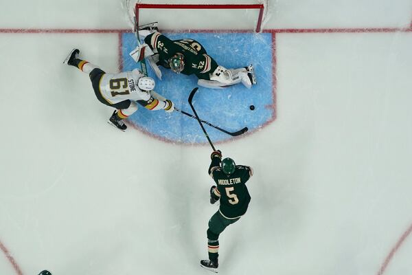Minnesota Wild goaltender Filip Gustavsson (32) and defenseman Jake Middleton (5) defend against a shot attempt by Vegas Golden Knights right wing Mark Stone (61) during the third period of Game 3 of a first-round NHL hockey playoff series Thursday, April 24, 2025, in St. Paul, Minn. (AP Photo/Abbie Parr)