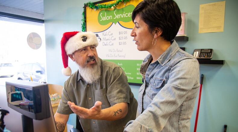 Dave Beltran-Roof talks with owner Nancy Anderson about appointment scheduling at Pigtails & Crewcut, a kids’ hairstyling salon in east Cobb, on Saturday, December 22, 2018. (Photo: STEVE SCHAEFER / SPECIAL TO THE AJC)