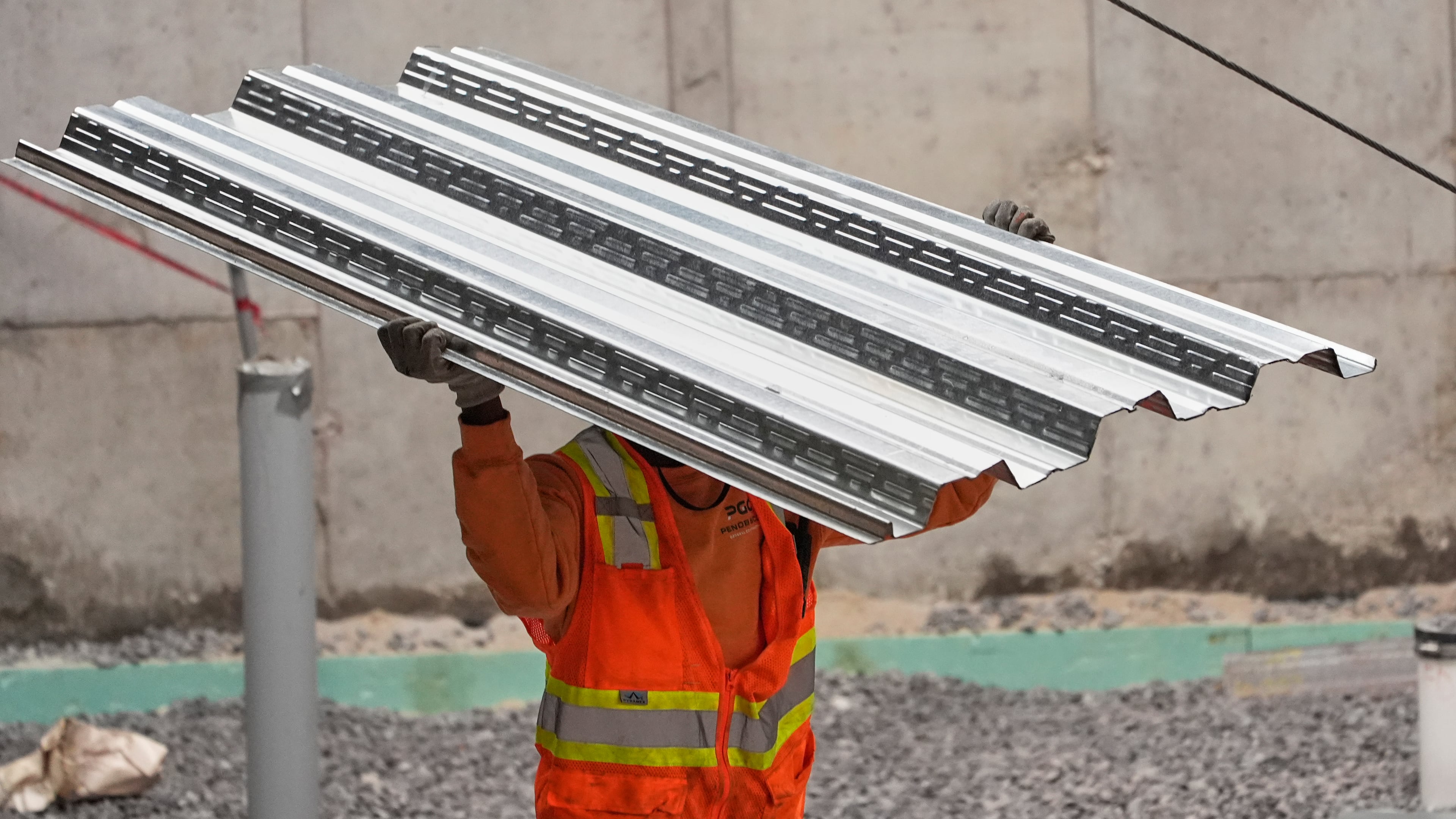 FILE - A construction worker carries steel decking at the site of a construction of a housing project, Thursday, July 31, 2025, in Portland, Maine. (AP Photo/Robert F. Bukaty, File)