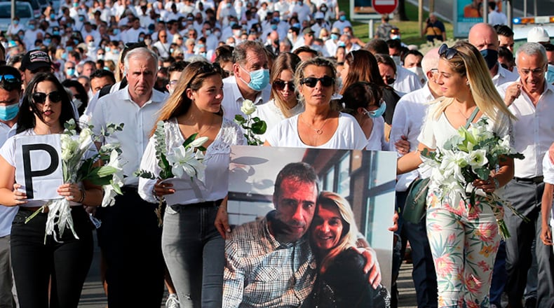 Veronique Monguillot, wife of Philippe Monguillot, a bus driver who was attacked in Bayonne, holds a photo of her with her husband during a protest march in Bayonne, southwestern France. The wife of the French bus driver savagely beaten after he asked four of his passengers to wear face masks aboard his vehicle called for "exemplary punishment" after he died of his injuries.