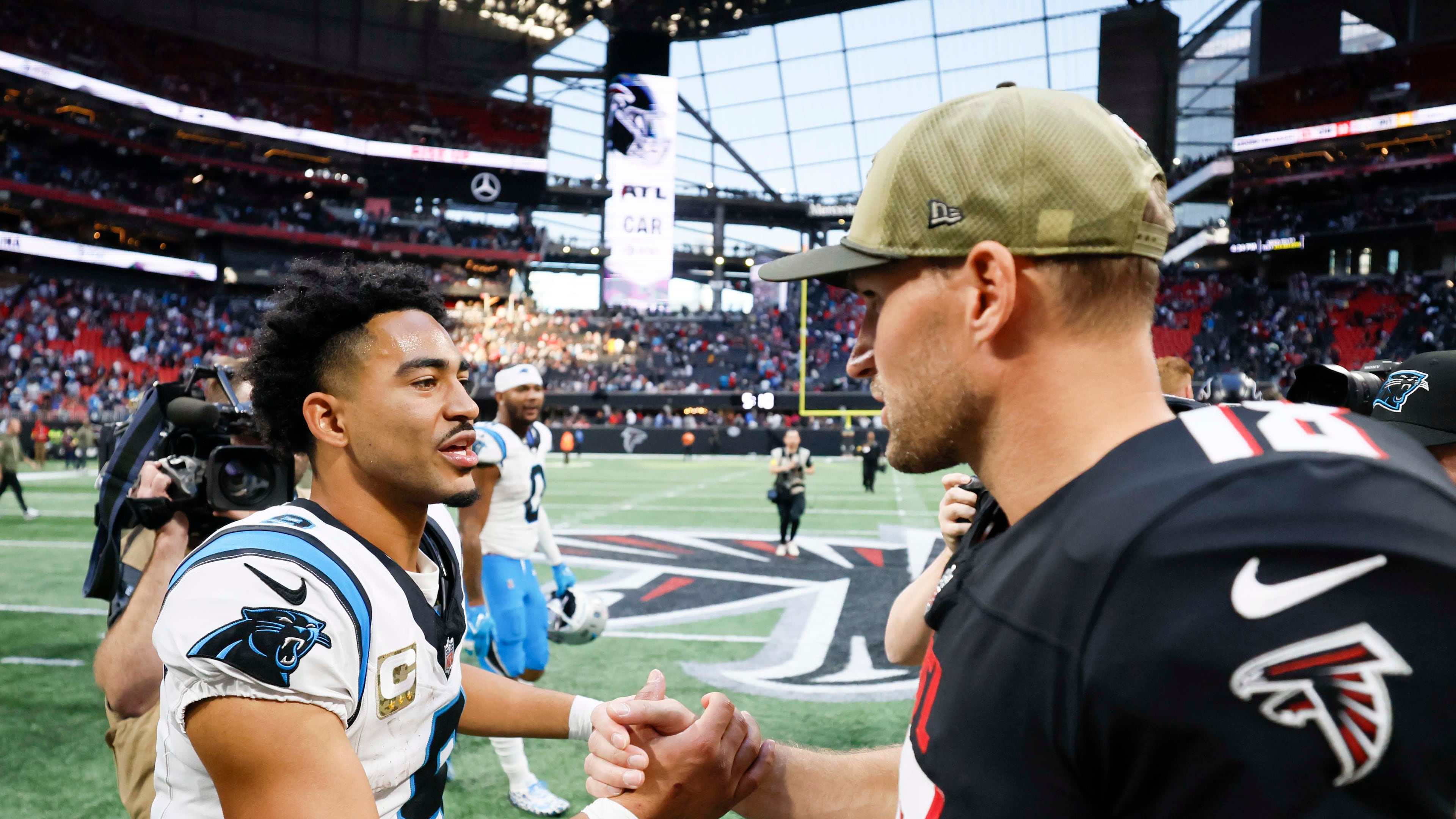 Atlanta Falcons quarterback Kirk Cousins (right) shakes hands with Carolina Panthers quarterback Bryce Young (left) after the Carolina Panthers defeated the Atlanta Falcons in overtime 30-27 at Mercedes-Benz Stadium in Atlanta on Sunday, Nov. 16, 2025. (Miguel Martinez/AJC)