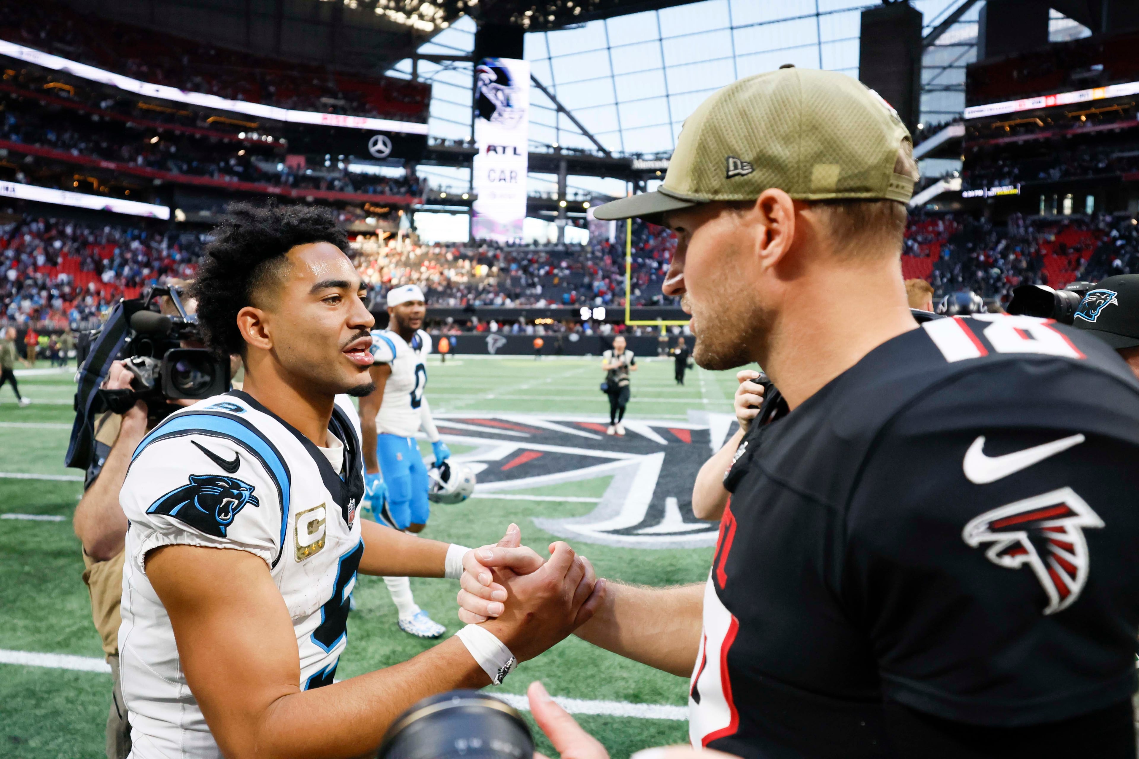 Atlanta Falcons quarterback Kirk Cousins (right) shakes hands with Carolina Panthers quarterback Bryce Young (left) after the Carolina Panthers defeated the Atlanta Falcons in overtime 30-27 at Mercedes-Benz Stadium in Atlanta on Sunday, Nov. 16, 2025. (Miguel Martinez/AJC)