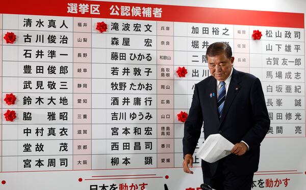 Shigeru Ishiba, Japan's Prime Minister and president of the ruling Liberal Democratic Party (LDP), walks before a board with few red paper roses showing elected candidate at the LDP headquarters in Tokyo, Sunday, July 20, 2025. (Franck Robichon, Pool Photo via AP)