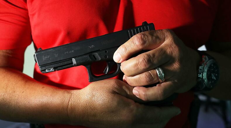 Miami police training officer Luis Gonzalez holds his pistol as he takes part in a demonstration Aug. 7, 2018.