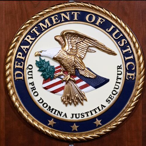 FILE - The seal of the Dept of Justice is shown on the podium, Aug. 1, 2023, at an office of the Department of Justice in Washington. (AP Photo/J. Scott Applewhite, File)