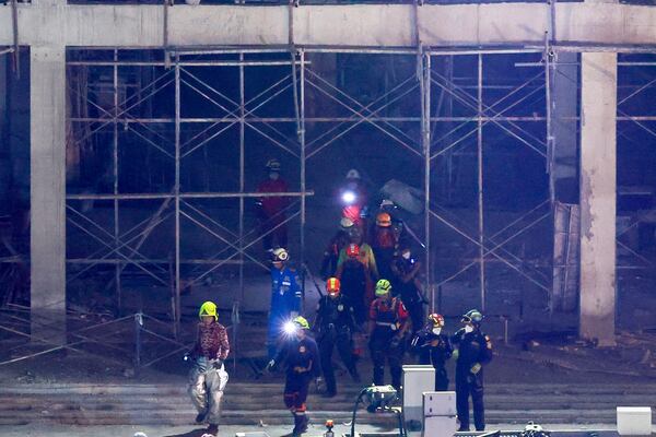 Rescuers return from the site of an under-construction high-rise building that collapsed on Friday after an earthquake in Bangkok, Thailand, Tuesday, April 1, 2025. (AP Photo/Wason Wanichakorn)