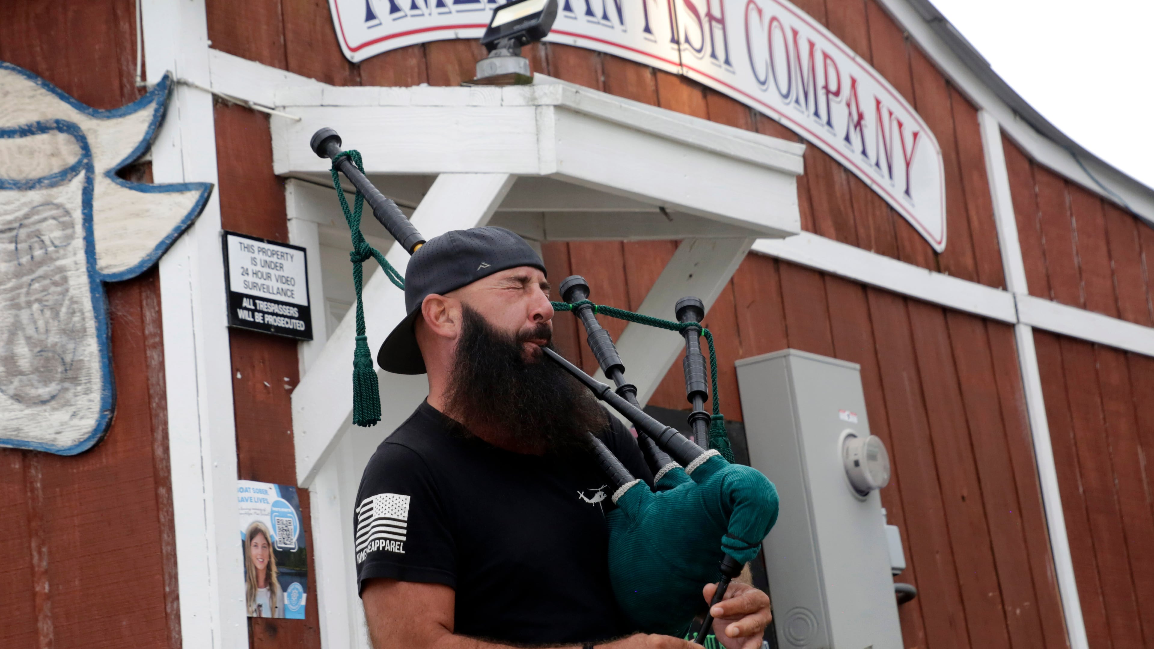 Joey Whitaker from Holden Beach plays "Amazing Grace" on the bagpipes in front of the American Fish Company following a fatal shooting that occurred here the night before, Sunday, Sept. 28, 2025, in Southport, N.C. (AP Photo/Chris Seward)