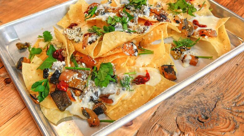Macho Nachos, crunchy corn tortillas, queso sauce, charred veggies, cotija and herbs, plus  add your favorite slow-cooked meat. CONTRIBUTED BY CHRIS HUNT PHOTOGRAPHY)