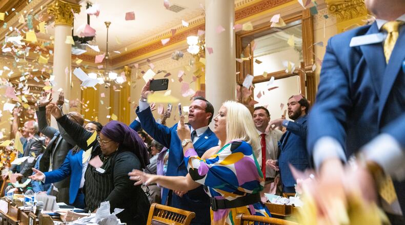 State senators throw papers in the air early Thurday to celebrate the end of the Georgia General Assembly's 2023 session. (Arvin Temkar / arvin.temkar@ajc.com)