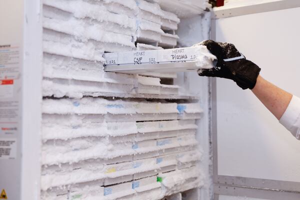 Whitney Wharton, a cognitive neuroscientist at Emory University, pulls research samples from the freezer. She is studying why the LGBTQ community reports early symptoms of the disease at higher rates than others. (Natrice Miller/AJC)
