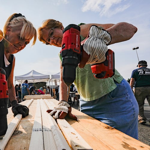 FILE - Volunteers Susan Chastain and Jenny Allen drill holes into two-by-fours during Bunks Across America, a non-profit event to build bunk beds for children in need at Lowe's, June 12, 2021 in East Brainerd, Tenn. (Troy Stolt/Chattanooga Times Free Press via AP, File)