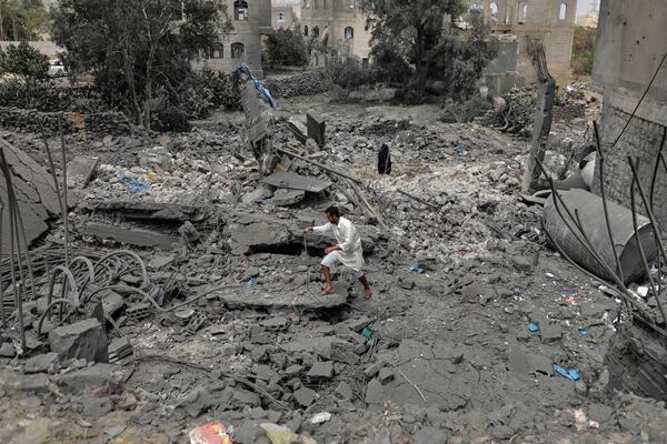 A Yemeni walks over the debris of a destroyed building following U.S. airstrikes in Sanaa, Yemen, Monday, March 24, 2025. (AP Photo)