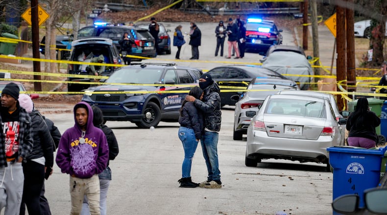Residents hug on Holderness Street as Atlanta police investigate a fatal shooting Monday.