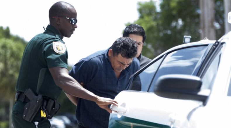 Employees of the Palm Beach County, Florida, Sheriff’s Office escort Nelson Hernandez Mena to a police car Sunday outside the Palm Beach County Sheriff’s Office in West Palm Beach Sunday August 6, 2017.