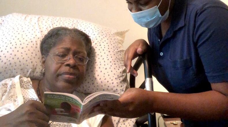 Caregiver Arnelle Souverain reads with a patient as part of Heart 2 Heart’s in-home care services. Contributed by Heart 2 Heart.