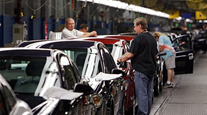 FILE - In this Tuesday, June 15, 2010, file photo, workers at General Motors' Lordstown Assembly plant in Lordstown, Ohio put the final touches on Chevy Cobalts. Falling demand for cars is forcing General Motors to lay off more than 2,000 workers indefinitely at two assembly plants in Ohio and Michigan starting in January 2017. The company says it will indefinitely suspend the third shifts at factories in Lordstown, Ohio, near Cleveland, and in Lansing, Mich., because customers are shifting from cars to SUVs and trucks. (AP Photo/Mark Duncan, File)
