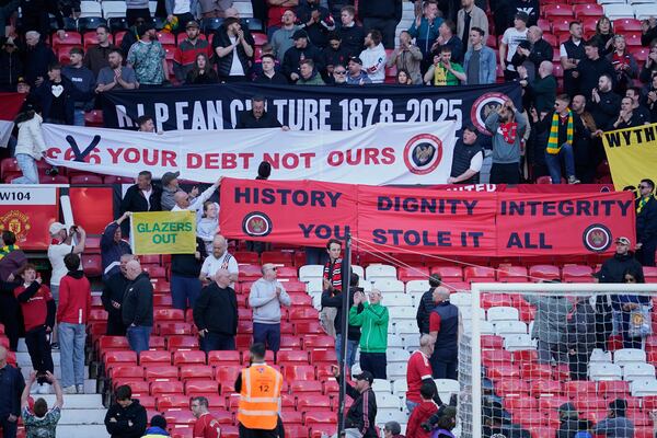 Mancheter United fans hold banners as they protest against the clunb's owners after the English Premier League soccer match between Manchester City and Manchester United in Manchester, England, Sunday, April 6, 2025. (AP Photo/Dave Thompson)
