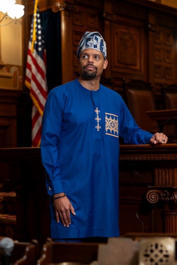 State Rep. Phil Olaleye, 41, wears a buba top and fila hat in the House of Representatives at the State Capitol in Atlanta. (Arvin Temkar/AJC)