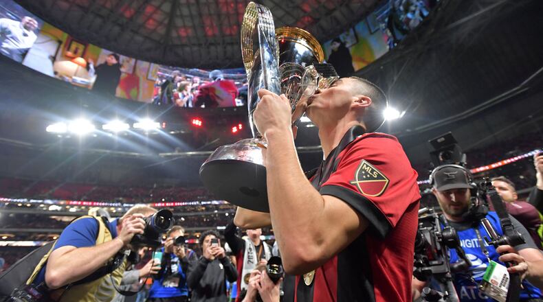 Atlanta United midfielder Miguel Almiron (10) kisses the MLS cup after United's victory. The Atlanta United soccer team defeated the Portland Timbers for the MLS Cup, the championship game of the Major League Soccer League at Mercedes-Benz Stadium in Atlanta. HYOSUB SHIN / HSHIN@AJC.COM