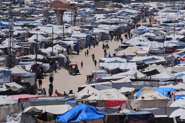 Displaced Palestinians walk through a makeshift tent camp in the Muwasi area of Khan Younis, in the Gaza Strip, on Monday, May 5, 2025. (AP Photo/Abdel Kareem Hana)