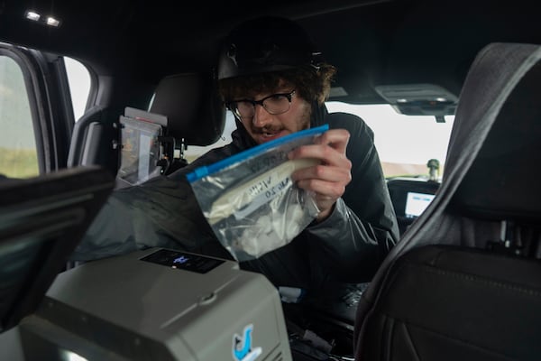 Tony Illenden turns to place a bag of hail he collected into a cooler in the backseat of the Northern Illinois University's Husky Hail Hunter during a Project ICECHIP operation Friday, June 6, 2025, in Levelland, Texas. (AP Photo/Carolyn Kaster)