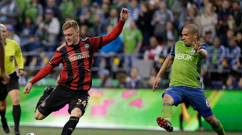 Atlanta United midfielder Julian Gressel, left gets a shot on goal off under pressure from Seattle Sounders midfielder Osvaldo Alonso, right, in the first half of an MLS soccer match, Friday, March 31, 2017, in Seattle. (AP Photo/Ted S. Warren)