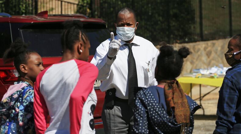 Fulton County District 6 Commissioner Joe Carn talks to kids during the Grab and Go free food and groceries event on Friday, April 17, 2020, at Allen Hills Apartments in Atlanta, which was organized to help families during the coronavirus pandemic. (Christina Matacotta, for The Atlanta Journal-Constitution)