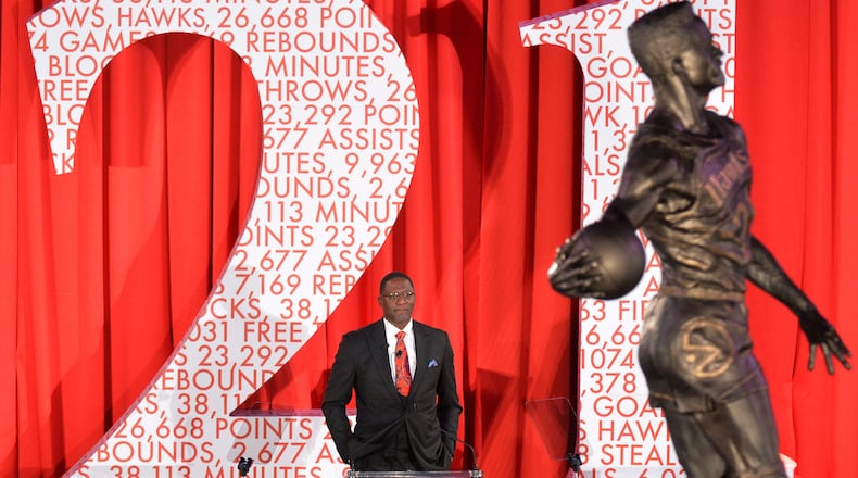 Dominique Wilkins gets emotional as he watches his statue is being unveiled at Philips Arena on Thursday, March 5, 2015. The Atlanta Hawks unveiled a large statue of former legendary Hawks player Dominique Wilkins on Thursday at Philips Arena. Measuring 13½ feet in height, the granite statue was unveiled at a private luncheon and ceremony on the arena floor. Made with a Nikon D4 camera, 200-400MM lens at focal length 220MM, 1/160 second, F4, and an ISO of 4000. HYOSUB SHIN / HSHIN@AJC.COM