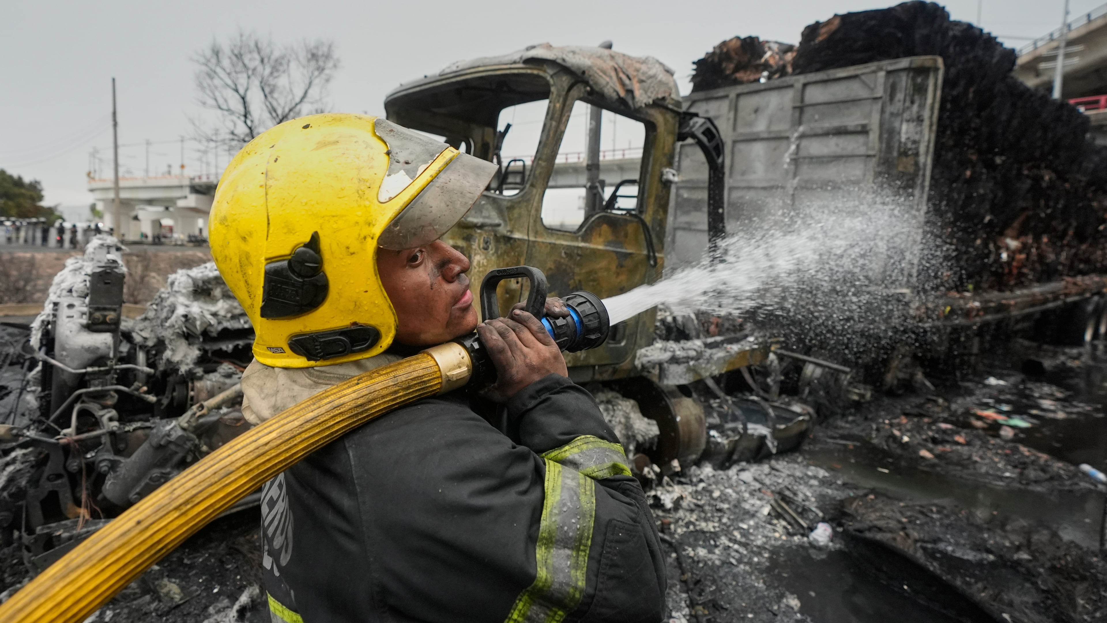 A firefighter sprays a hose after a gas tanker exploded in Mexico City, Wednesday, Sept. 10, 2025. (AP Photo/Fernando Llano)