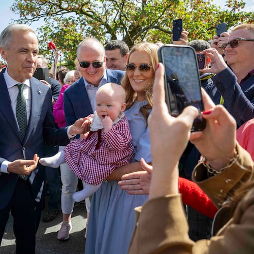 Canadian Prime Minister Mark Carney, front left, has a picture taken with Lily Meskil, 9 months and her grandfather Ger Basquel and mother Rachel Basquel, during a visit to Aughagower, Ireland, Sunday, June 14, 2026. (Andrew Downes/PA via AP)