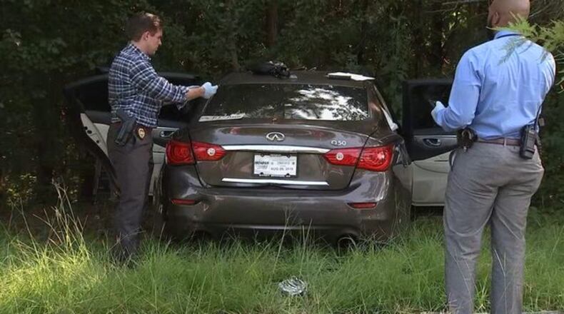 Investigators check a car that crashed early Thursday in northwest Atlanta.