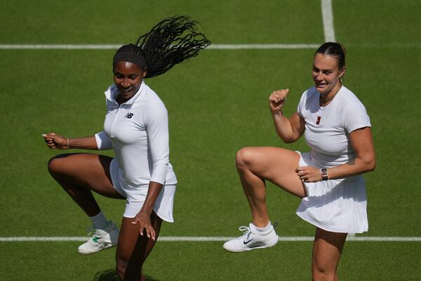 Aryna Sabalenka of Belarus, right, and Coco Gauff of United States dance during a practice session ahead of the Wimbledon Championships in London, Friday, June 27, 2025. (AP Photo/Kin Cheung)