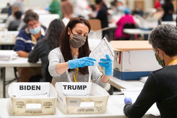 An election worker looks at a ballot during a hand recount of Presidential votes on Sunday, Nov.15, 2020 in Marietta, Ga. (John Amis / The Atlanta Journal-Constitution / AP) 
