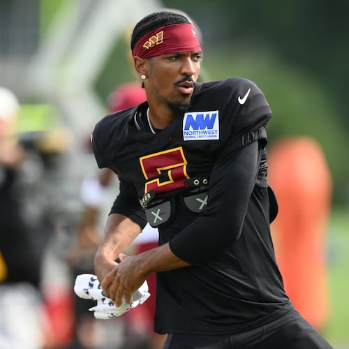 Washington Commanders quarterback Jayden Daniels works out before a joint practice with the Miami Dolphins at NFL football training camp, Wednesday, Aug. 12, 2026 in Ashburn, Va. (AP Photo/Nick Wass)