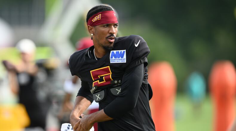 Washington Commanders quarterback Jayden Daniels works out before a joint practice with the Miami Dolphins at NFL football training camp, Wednesday, Aug. 12, 2026 in Ashburn, Va. (AP Photo/Nick Wass)