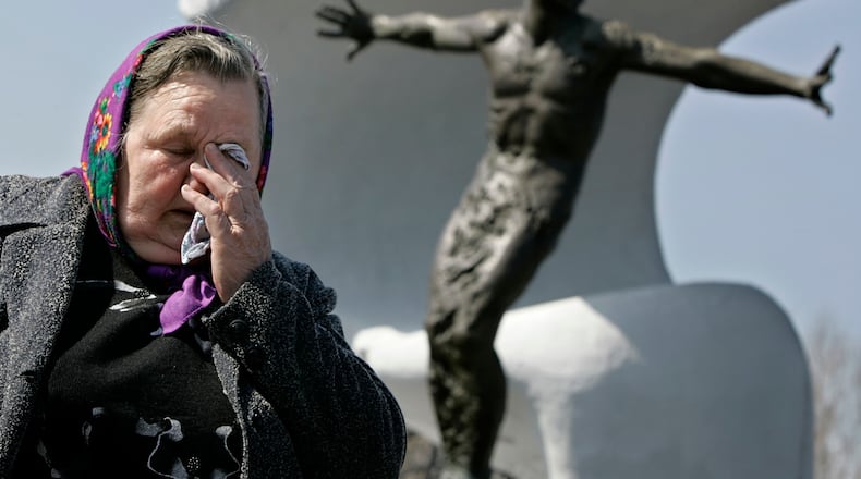 FILE – Tatyana Ignatenko, the mother of firefighter Vasily Ignatenko, grieves near his grave at Mitinskoye Cemetery in Moscow, Russia, on Wednesday, April 26, 2006, the 20th anniversary of the explosion and fire at the Chernobyl nuclear power plant in Ukraine. Vasily Ignatenko's crew was the first to respond to the disaster. (AP Photo/Alexander Zemlianichenko, File)