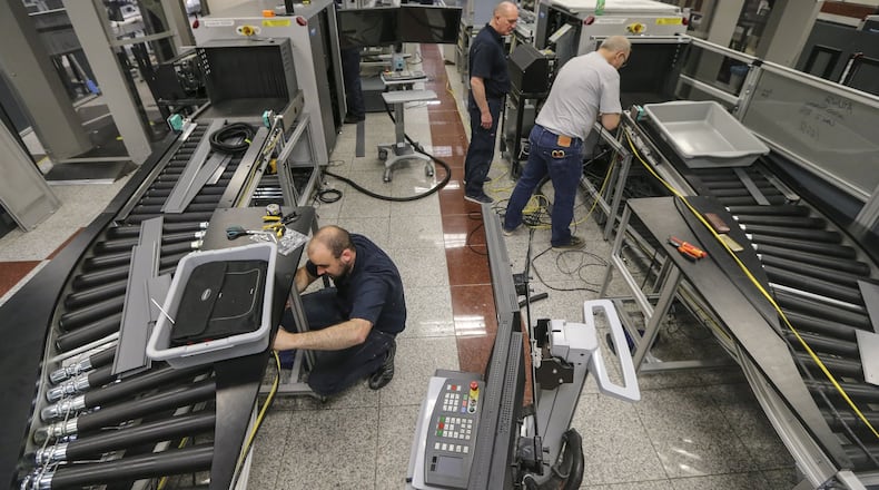 Workers install equipment for new “smart lanes” at Hartsfield-Jackson’s South security checkpoint in 2016. The airport says installation is now complete on 22 of 27 checkpoint lanes throughout the domestic terminal. JOHN SPINK / JSPINK@AJC.COM