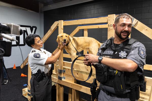Cobb County sheriff's K-9 Sherlock poses for photos with Assistant Chief Gina Hawkins (left) and Deputy Carl Cramer, his handler.