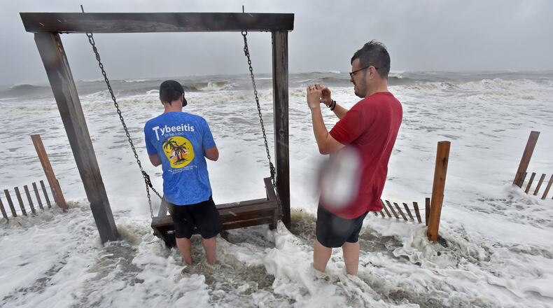 Tybee Island - Brett Lay (left) and James Simpson snap pictures as Hurricane Dorian approaches Wednesday, September 4, 2019.