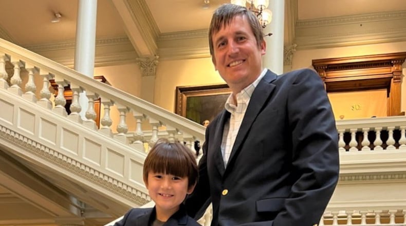 Democrat Russell Edwards and son Teddy, 8, after he qualified to run for Public Service Commission on March 11. Edwards said Tuesday that we was suspending his campaign for the District 2 seat currently held by Tim Echols, a Republican.