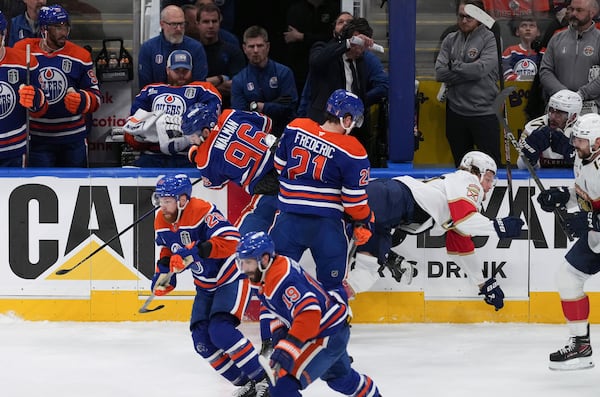 Edmonton Oilers' Jake Walman (96) checks Florida Panthers' Jesper Boqvist, back right, during the first period in Game 1 of the NHL Stanley Cup Final, in Edmonton, Alberta, on Wednesday, June 4, 2025. (Darryl Dyck/The Canadian Press via AP)
