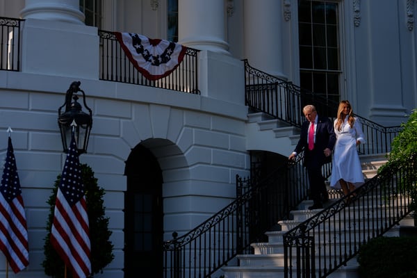 President Donald Trump and first lady Melania Trump walk down the steps from the Blue Room Balcony to sign his signature bill of tax breaks and spending cuts at the White House, Friday, July 4, 2025, in Washington. (AP Photo/Julia Demaree Nikhinson)