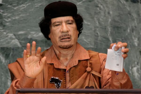 FILE - Libyan leader Moammar Gadhafi shows a torn copy of the UN Charter during his address to the 64th session of the United Nations General Assembly, Sept. 23, 2009. (AP Photo/Richard Drew, File)