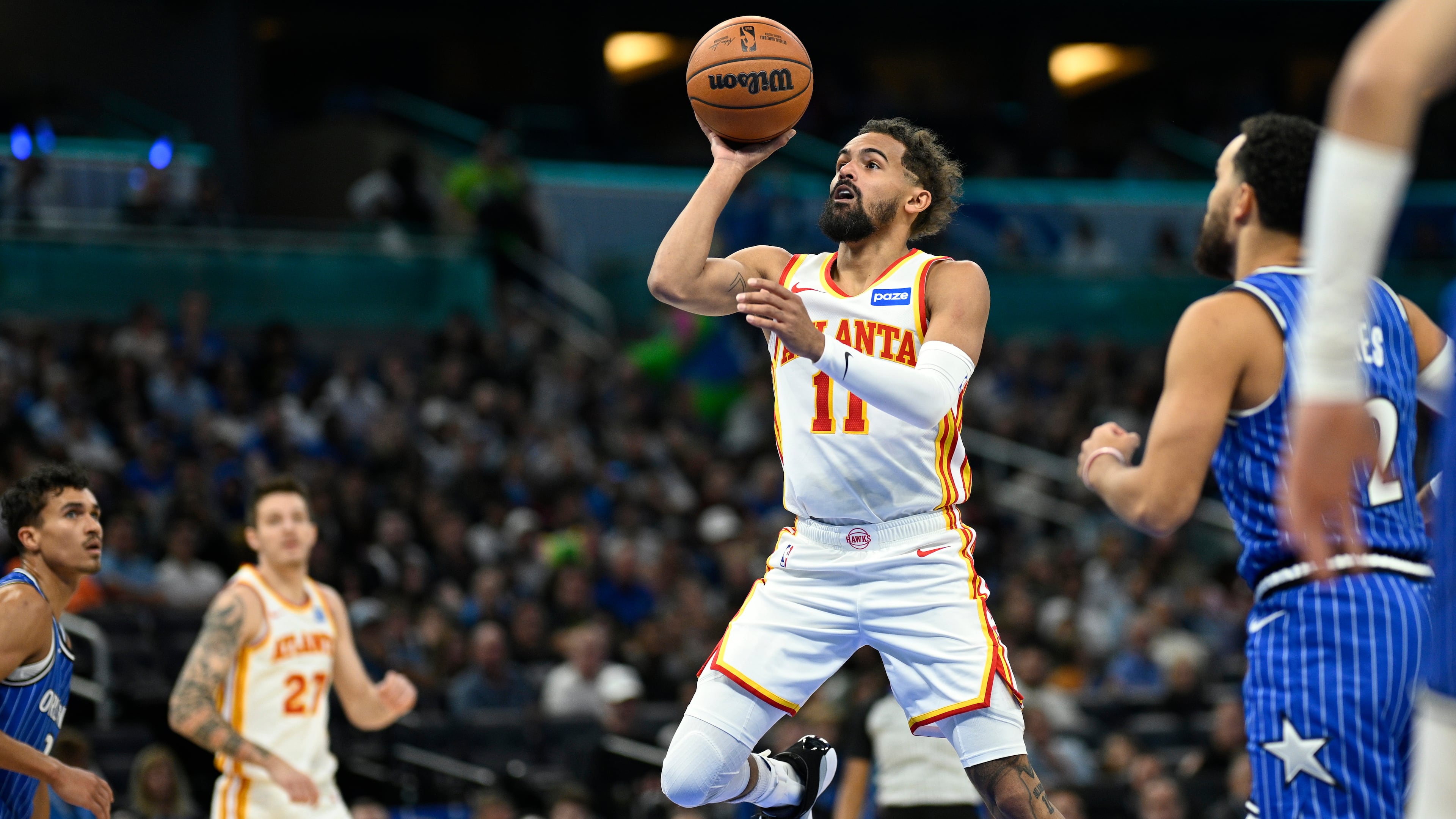 Atlanta Hawks guard Trae Young (11) goes up to shoot in front of Orlando Magic guard Tyus Jones (2) during the first half of an NBA basketball game Friday, Oct. 24, 2025, in Orlando, Fla. (AP Photo/Phelan M. Ebenhack)
