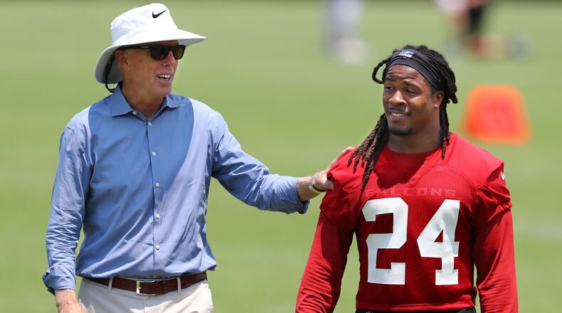Atlanta Falcons President and CEO Rich McKay gives running back Devonta Freeman a pat  on the back during team practice on Thursday, May 23, 2019, in Flowery Branch.
