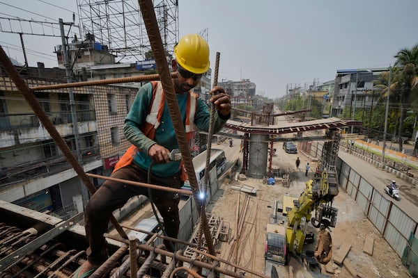 A labourer works on the construction of a bridge in Guwahati, India, Tuesday, April 8, 2025. (AP Photo/Anupam Nath)