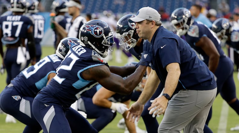 File-This Aug. 30, 2018, file photo shows Tennessee Titans tight ends coach Arthur Smith, right, helping tight end Delanie Walker (82) warm up before a preseason NFL football game in Nashville, Tenn. Mike Vrabel has stayed inside the Tennessee Titans' organization for his new offensive coordinator, promoting tight ends assistant Smith to the job vacated when Matt LaFleur left for the Green Bay Packers' head coaching job. Vrabel announced the promotion Monday, jan. 21, 2019, saying he's excited for both Smith and the Titans to promote a "deserving coach."(James Kenney/AP)
