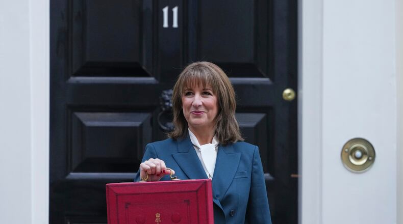 Britain's Chancellor of the Exchequer Rachel Reeves poses on the doorstep of 11 Downing Street with her ministerial red box before heading to the House of Commons to deliver her Budget speech in London, Wednesday, Nov. 26, 2025. (AP Photo/Kirsty Wigglesworth)